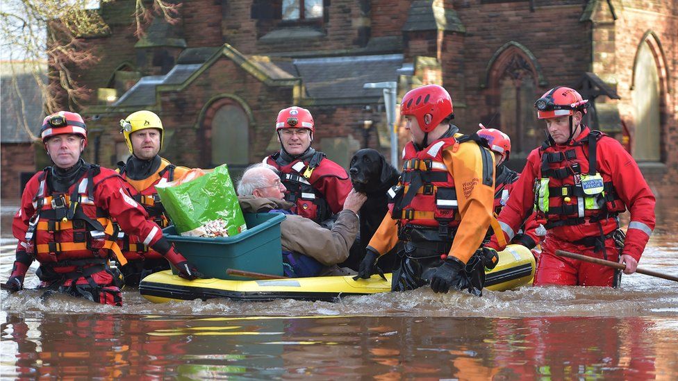 A pensioner and his dog are taken to safety on a dinghy by emergency services