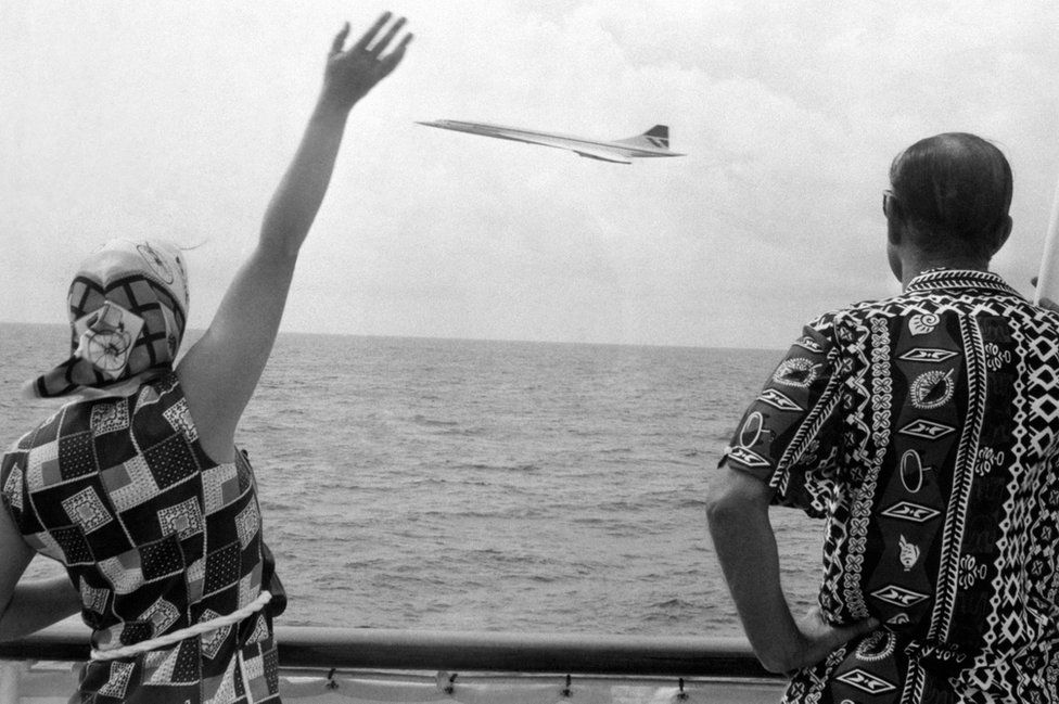 Queen Elizabeth II and the Duke of Edinburgh wave as Concorde flies by the Royal Yacht Britannia as the royal couple neared Barbados