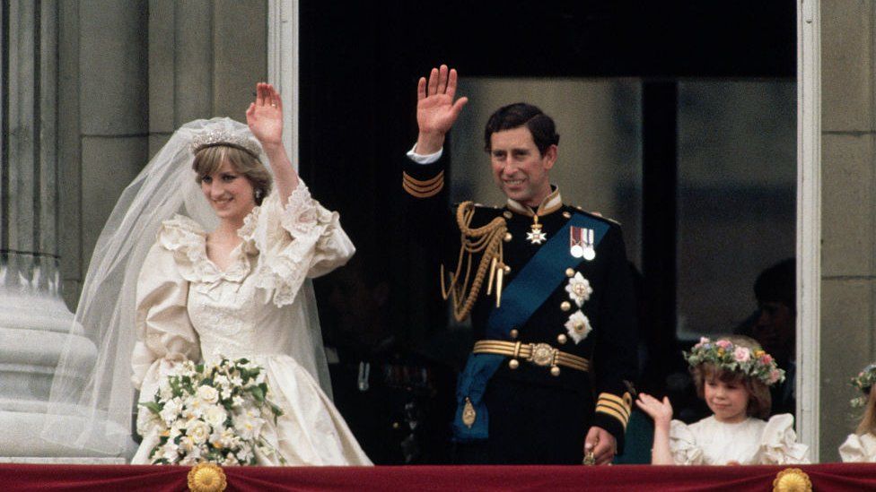 Princess Diana and Prince Charles wave to onlookers from the balcony at Buckingham Palace just after their wedding, attended by young members of the bridal party