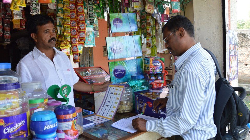 Shopkeeper Anand Talekar and a Mondelez salesman