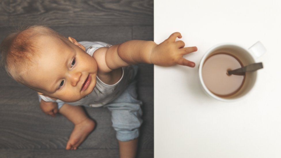Baby reaching for a hot cup of tea