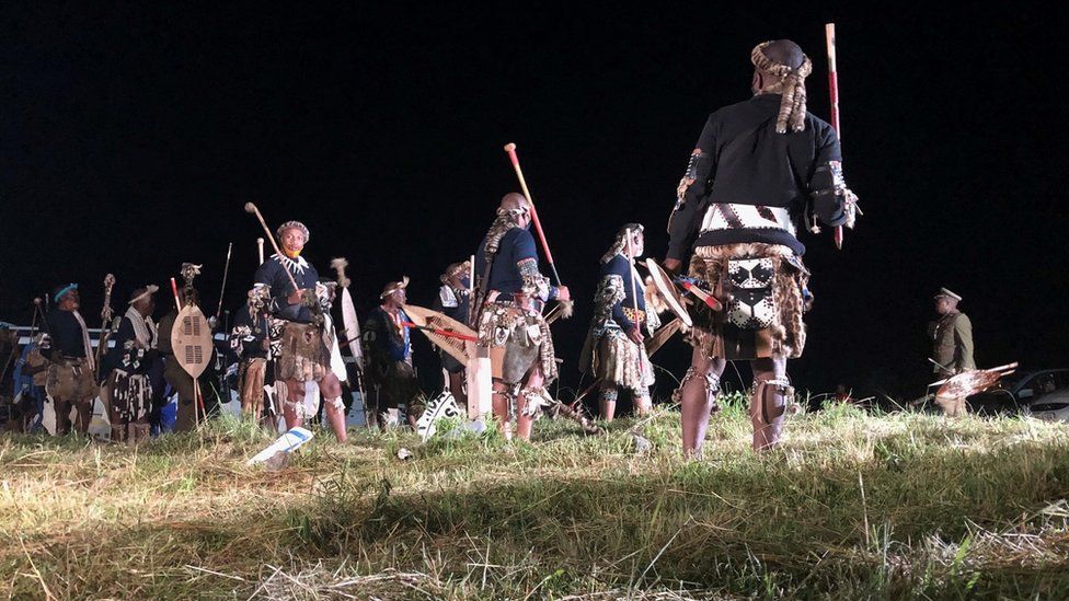 Zulu men in traditional warrior outfits at night in Nongoma, South Africa - March 2021