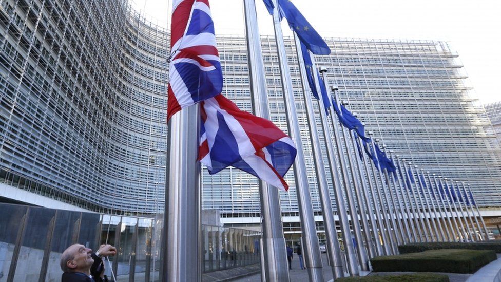 A Union Jack flag next to European Union flags at the EU Commission headquarters in Brussels