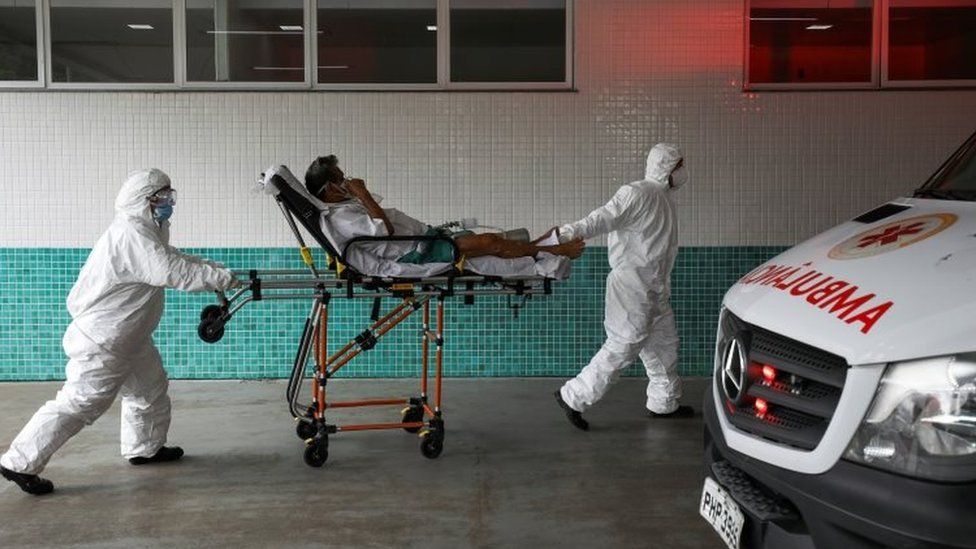 Health workers transport Joao Oliveira, 77, who, according to his wife, is suffering with COVID-19 symptoms, at 28 de Agosto hospital