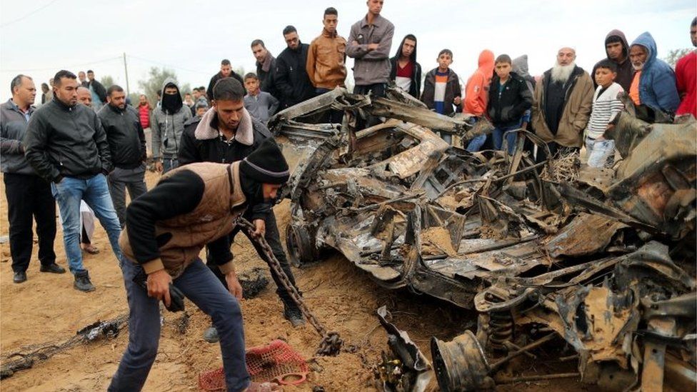 Palestinians look at wreckage of car destroyed in Israeli air strike in Khan Younis (12/11/18)