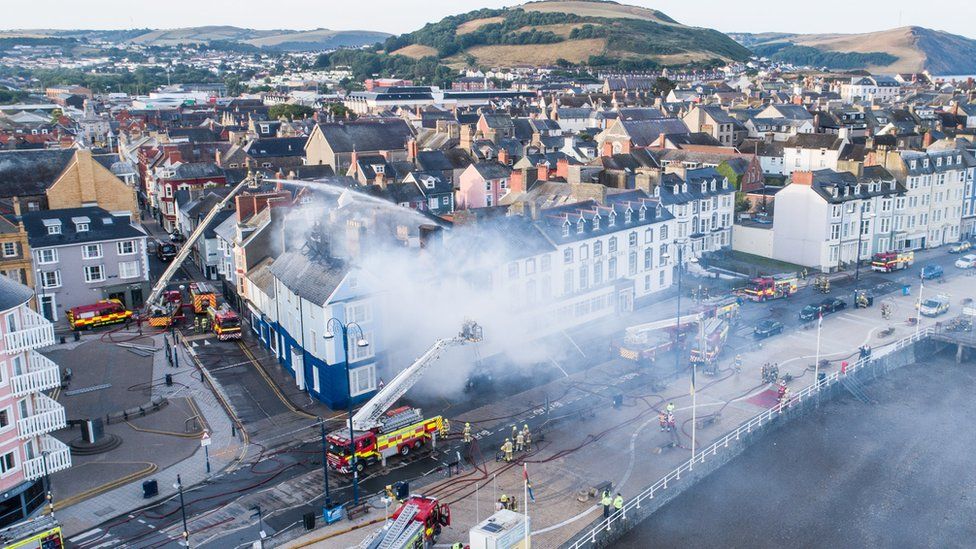 Aerial view of Aberystwyth with fire engines damping down the hotel