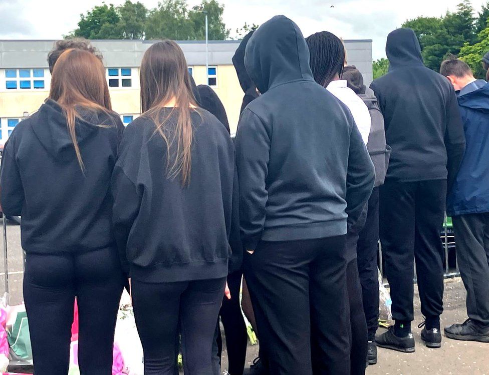 Pupils gather to look at floral tributes at St Kentigern's Academy
