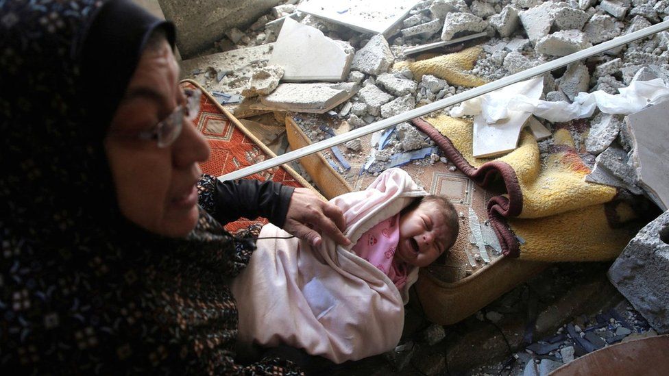 A Palestinian baby cries at a house damaged by an Israeli air strike in Rafah, in the southern Gaza Strip (29 April 2024)