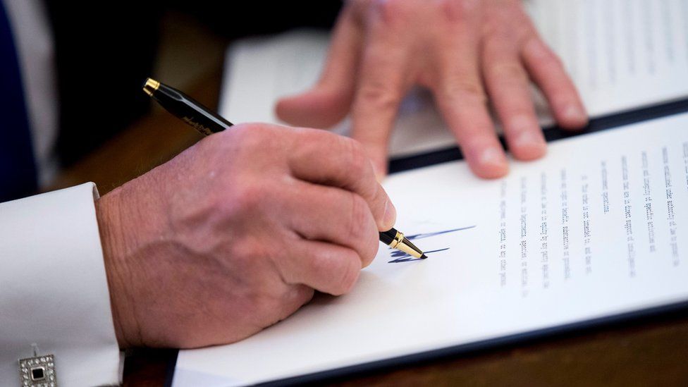 US President Donald Trump signs one of five executive orders related to the oil pipeline industry in the oval office of the White House in Washington, DC USA, 24 January