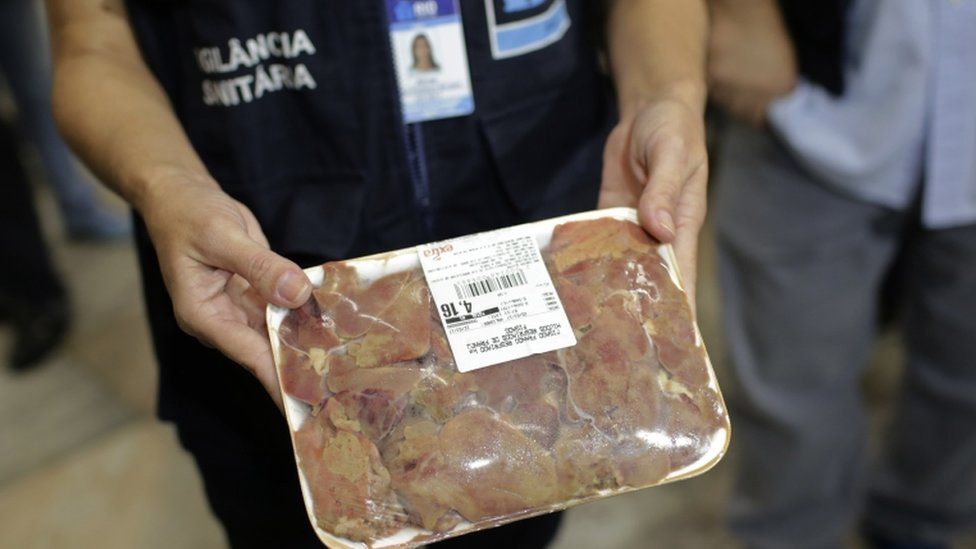 A Municipal Sanitary Surveillance worker show a package of chicken in bad condition during an inspections at a supermarket in Rio de Janeiro