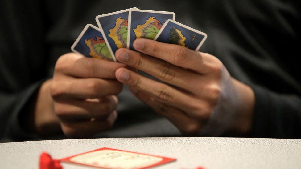 Hand holds Catan cards