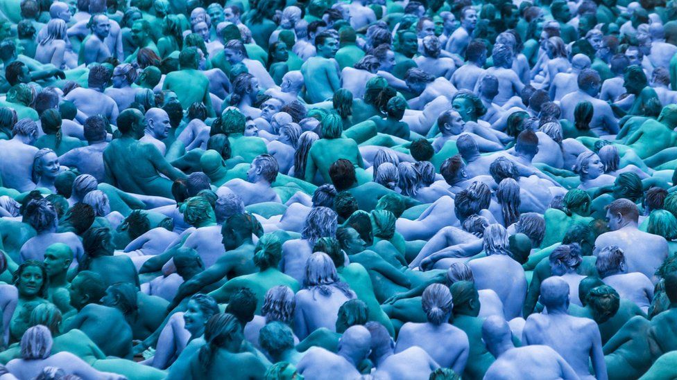 Nude people painted blue