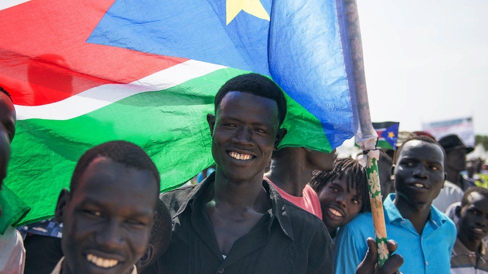 A man holds South Sudan's national flag during the country's fourth independence day celebrations on July 9, 2015 at John Garang Mausoleum grounds in Juba