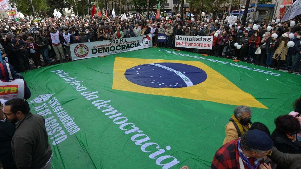 A Brazilian flag is spread on the ground during a democracy demonstration in Sao Paulo
