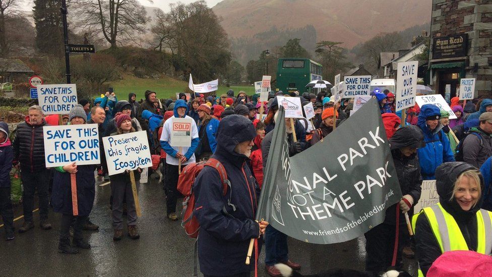 Protesters with placards and banners in Grasmere ahead of the march