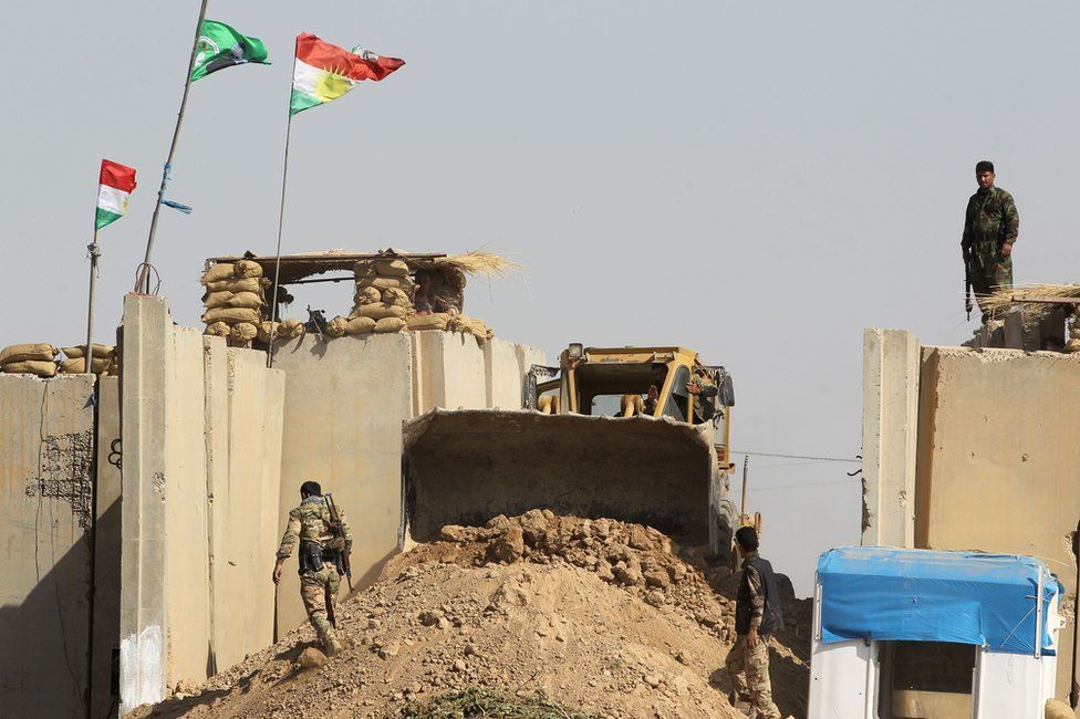 Kurdish Peshmerga fighters hold a position on a riverbank across on 14 October 2017, on the southern outskirts of Kirkuk