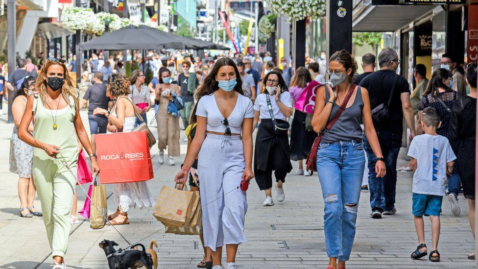 Women wearing face masks as a precaution against the spread of Covid-19, walk along Meritxell avenue in Andorra la Vella in 2021