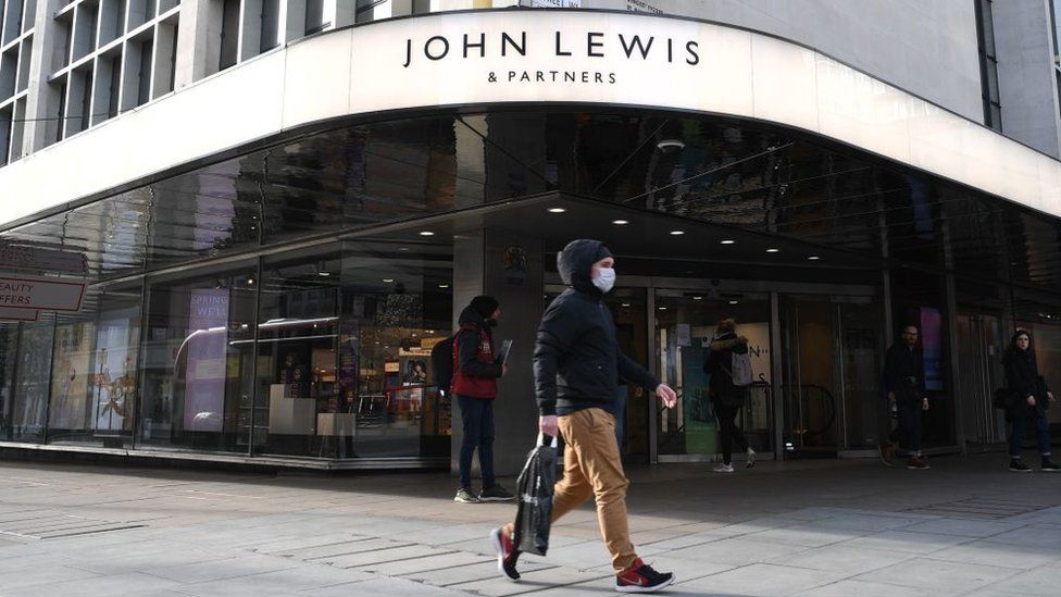 Shopper walking past John Lewis storefront