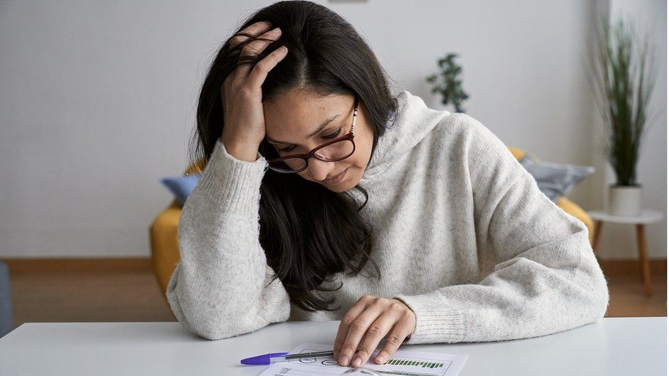 Woman looking at energy bill - stock shot