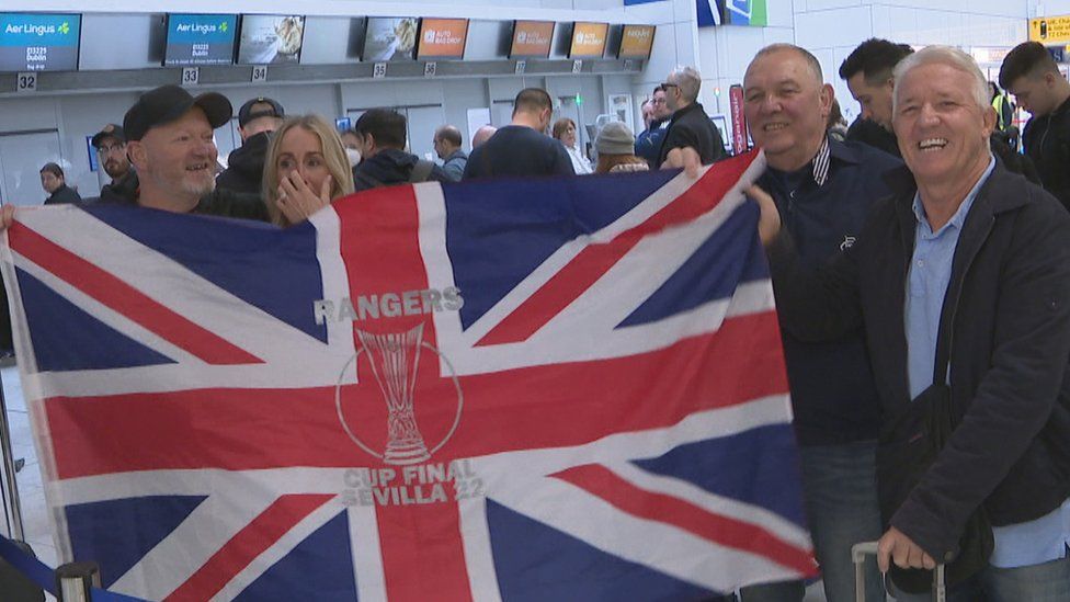 Rangers fans with a flag at Glasgow Airport