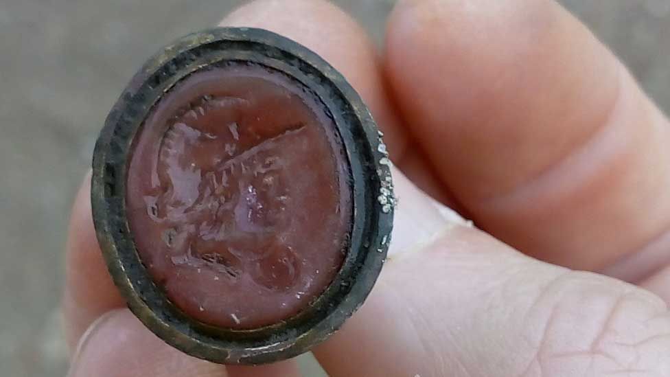 A press seal showing a man's head wearing a military helmet