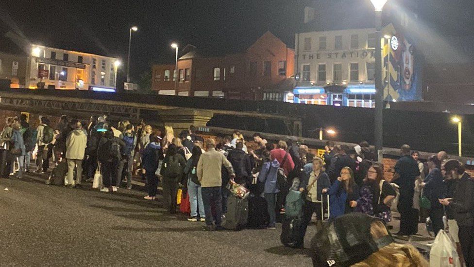 People wait at Preston train station for replacement taxis