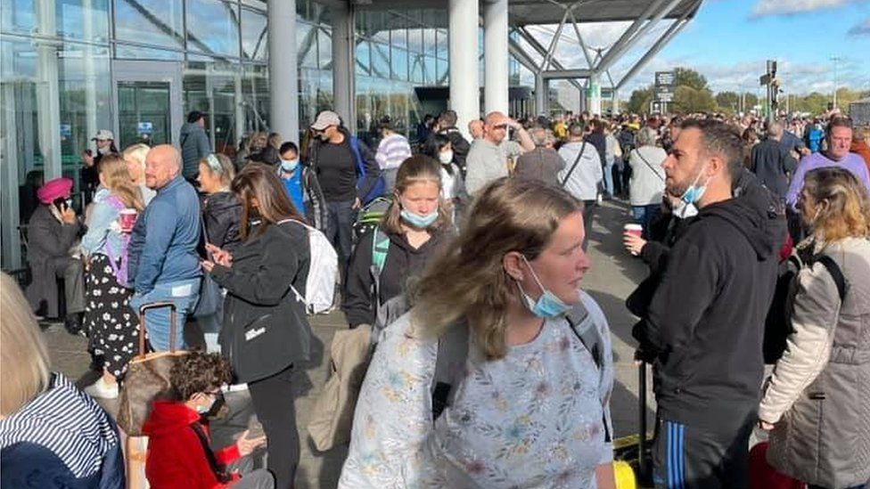 Passengers waiting outside Stansted Airport