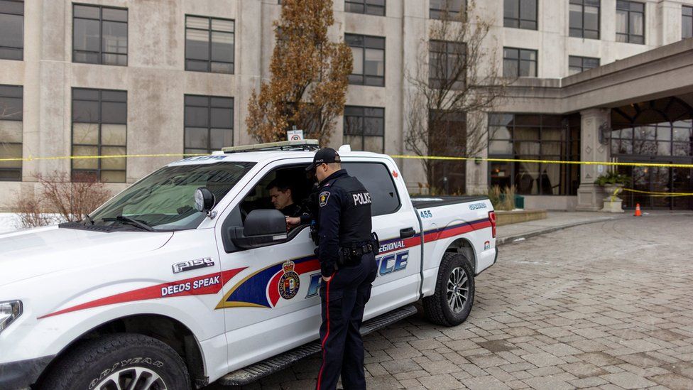 Полицейские стоят возле здания после массовой стрельбы со смертельным исходом в пригороде Торонто Вон