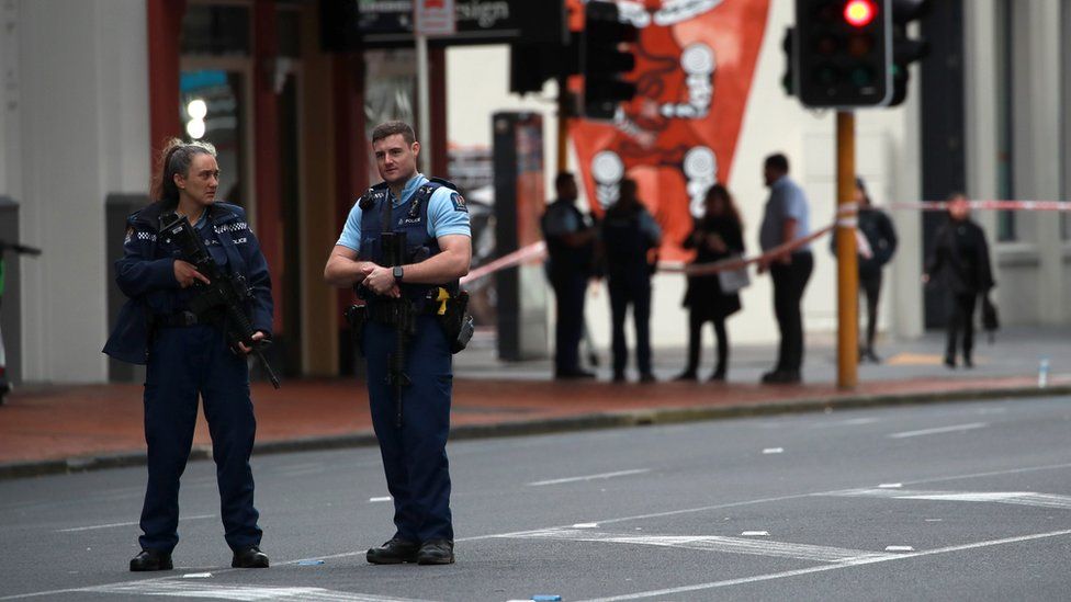 Police stand guard at a cordoned off area near the site of a shooting in Auckland, New Zealand