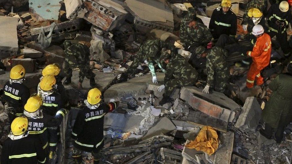 Rescuers search for survivors among debris after a residential building collapsed in Wuyang county, Henan province, China October 30, 2015.