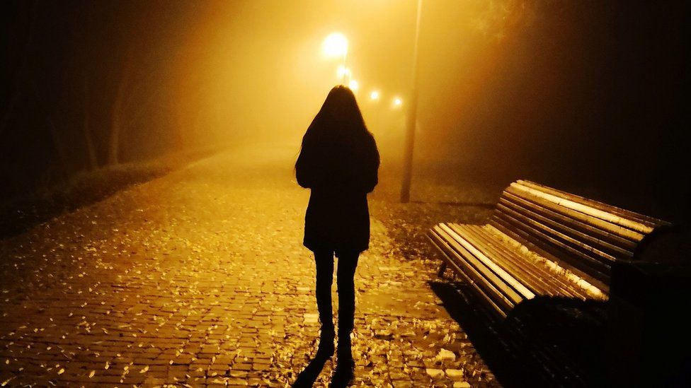 A woman walking alone at night