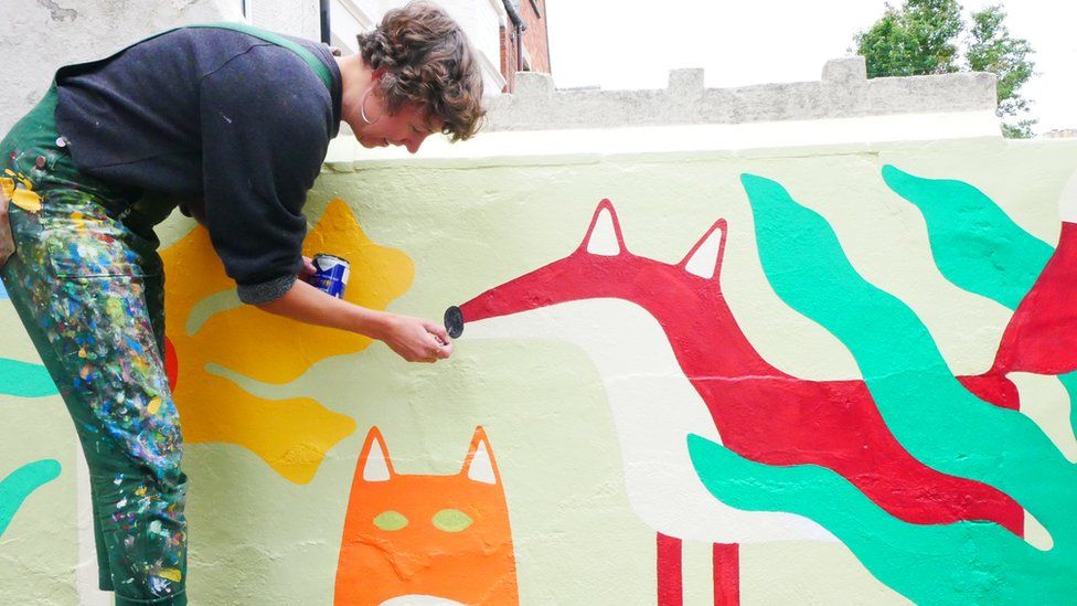 Lisa Made It painting a fox for the mural