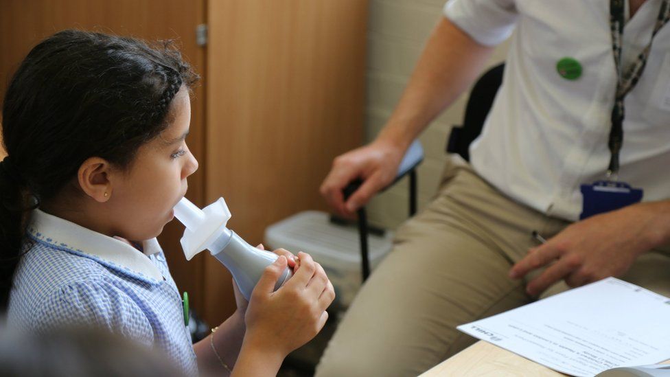 Child blowing into spirometer