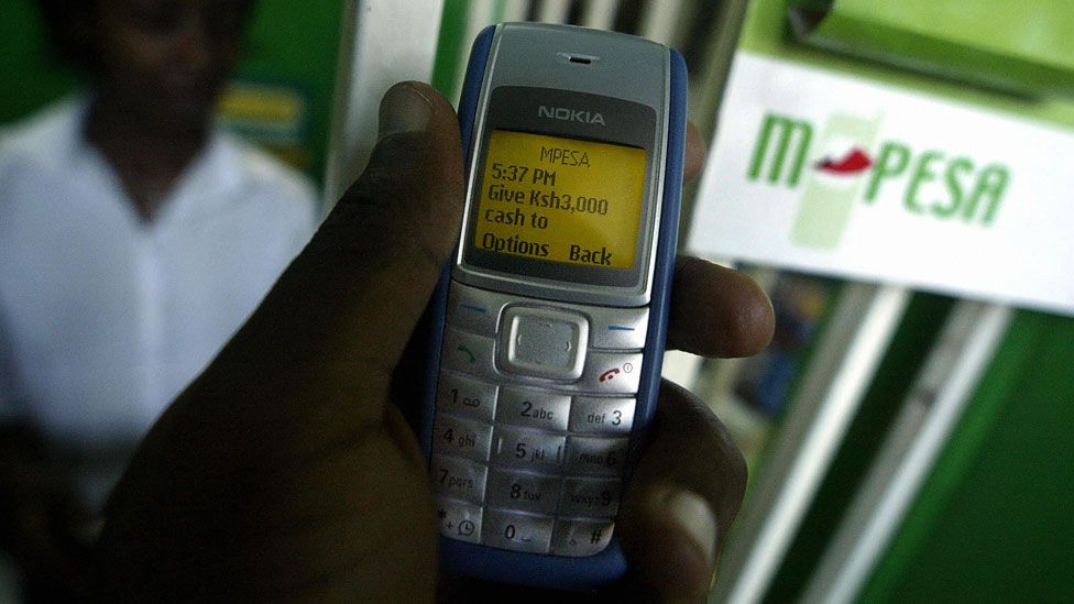 A man sending money via M-Pesa, in Nairobi