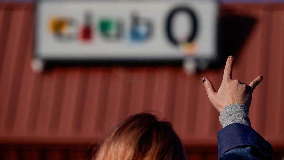 A person gestures with their hand at Club Q after a mass shooting at the LGBT nightclub in Colorado Springs,