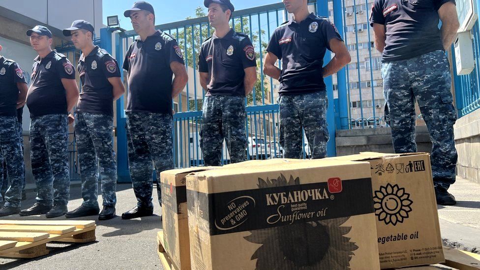 Soldiers stand by boxes filled with sunflower oil outside UN offices in Yerevan