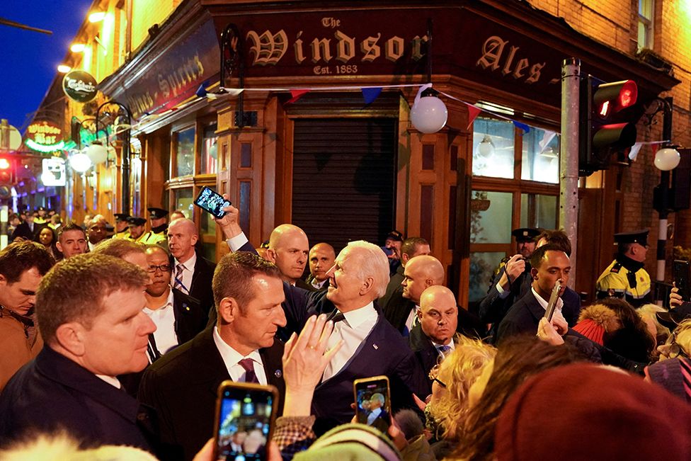 US President Joe Biden takes a selfie outside a pub in Dundalk, Ireland, on 12 April 2023