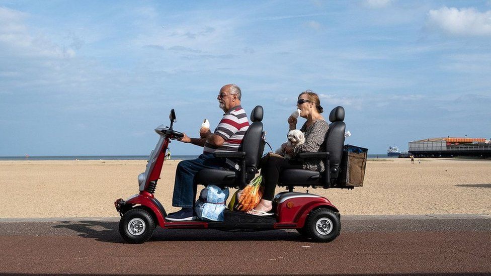 Photo of two people on a double mobility scooter