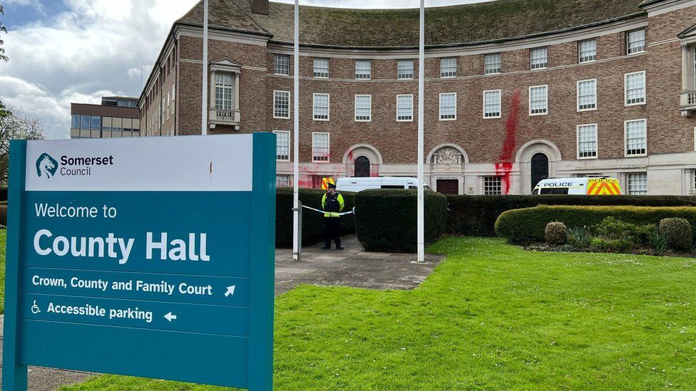county hall sign with police vans outside building