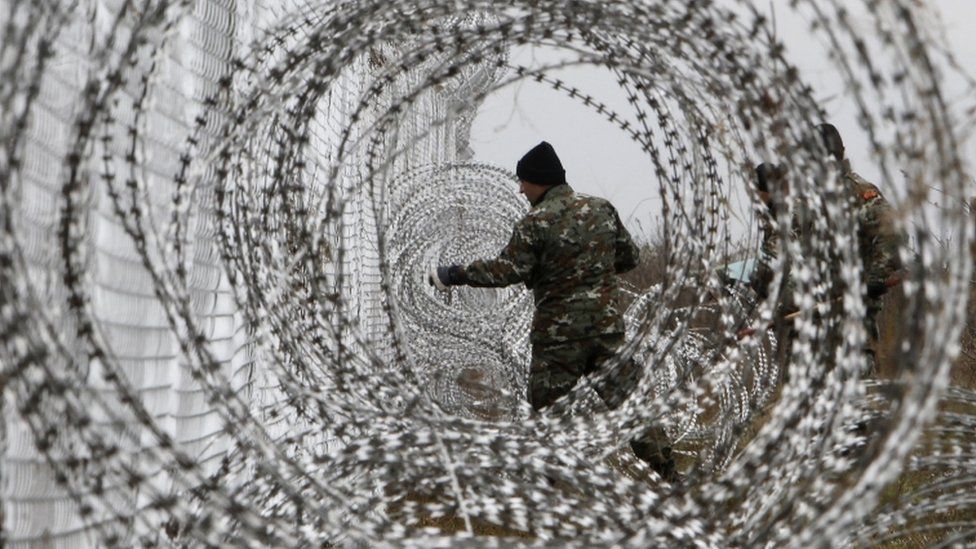 A Macedonian Army engineer fixes razor wire to a fence at the border crossing Medzitlija, between Macedonia and Greece. 11 Dec