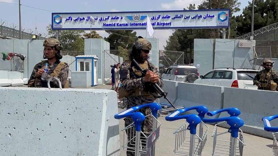 Taliban forces stand guard at the entrance of Hamid Karzai International Airport in Kabul, 31 August 2021
