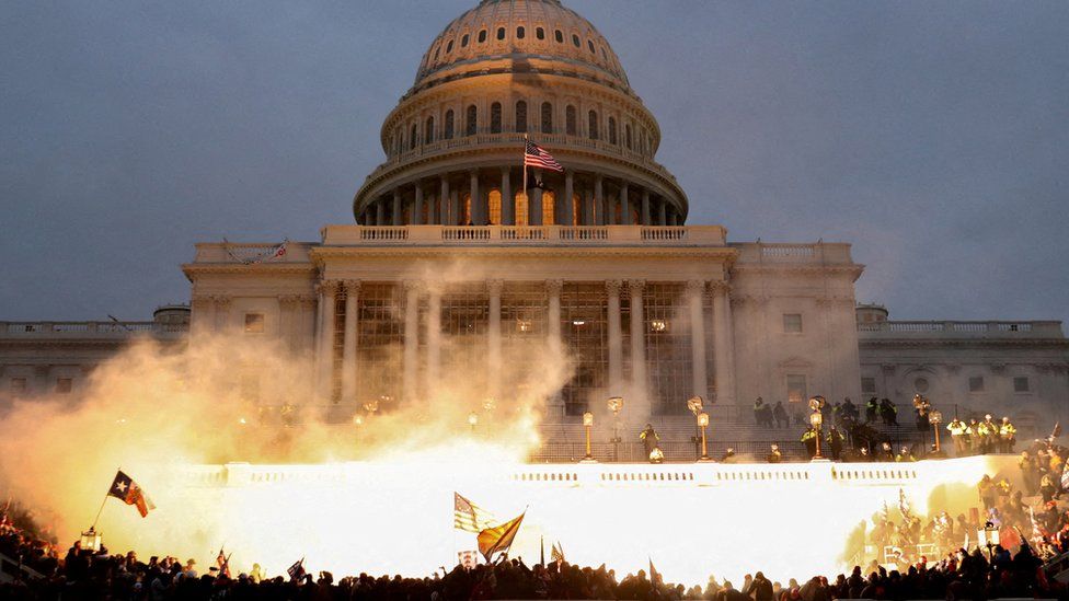 Smoke, light and fire in front of US Capitol at dusk