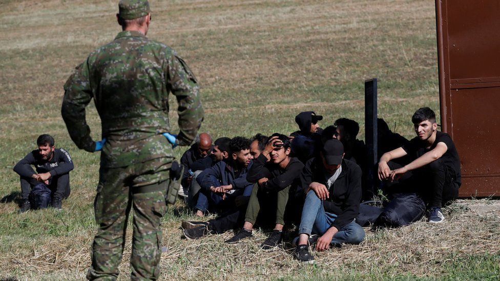 Migranten warten, während sie von der slowakischen Polizei festgenommen werden, nachdem sie am 15. September 2023 illegal die Grenze nahe der slowakisch-ungarischen Grenze im Dorf Chl'aba in der Slowakei überquert haben