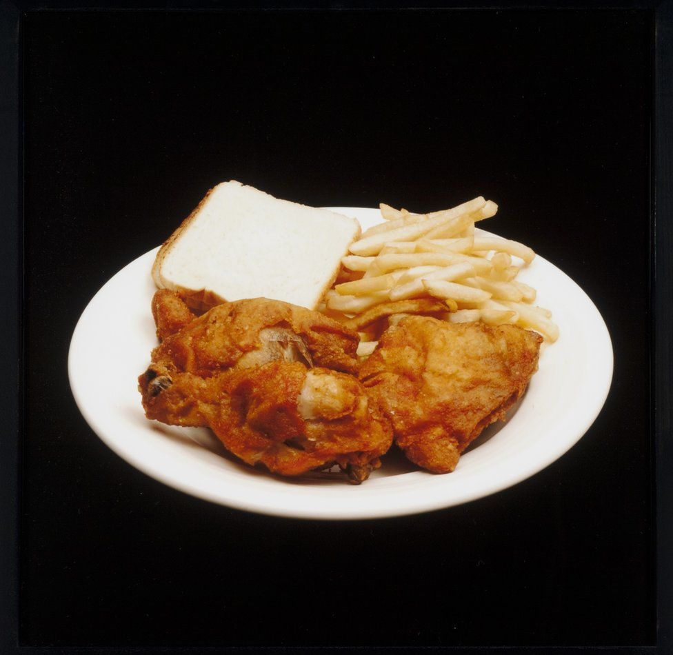 A meal featuring french fries, fried chicken and white bread