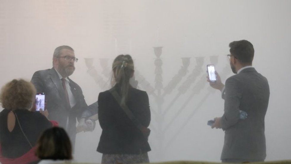 Grzegorz Braun (L) after putting out candles on menorah