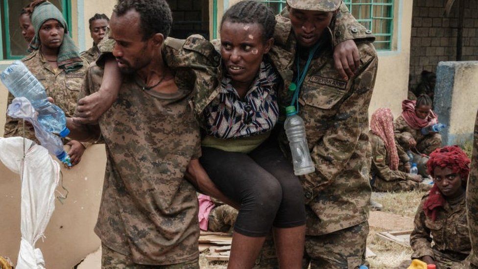 Captive Ethiopian soldiers carry a wounded soldier upon arrival at the Mekele Rehabilitation Center in Mekele, the capital of Ethiopia's Tigray region, on July 2, 2021.