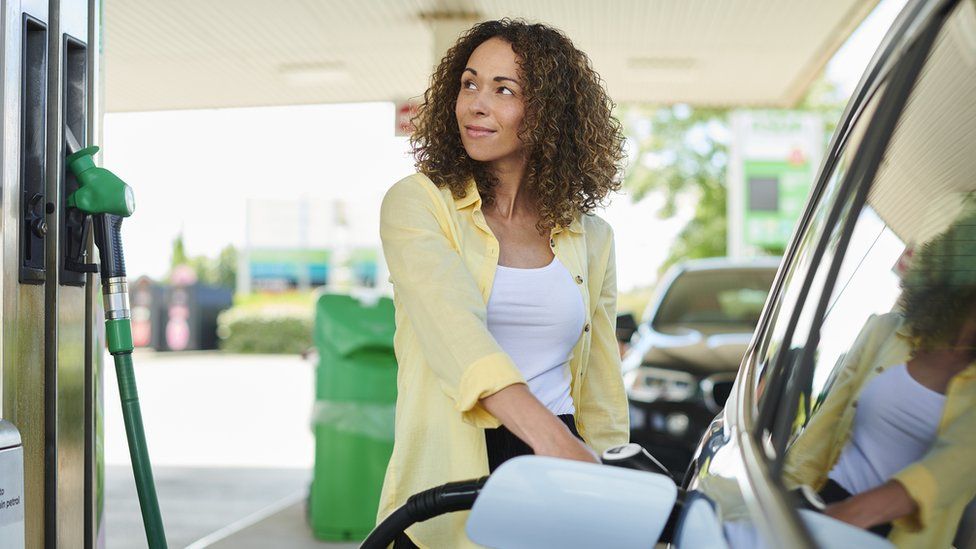 Woman filling up at a petrol pump