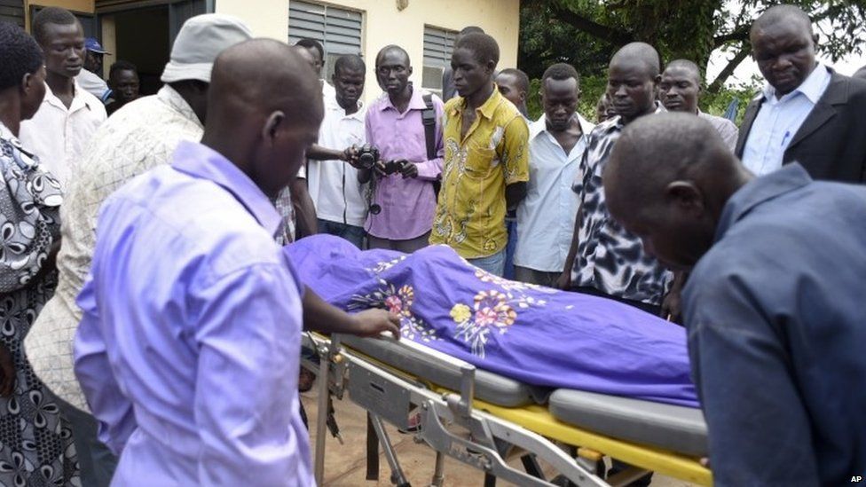 Relatives and other mourners watch as the body of South Sudanese journalist Peter Julius Moi is taken into the mortuary in Juba, South Sudan Thursday, 20 August 2015