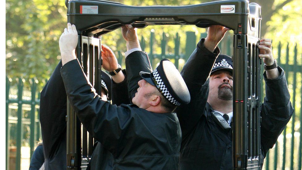 Police officers erect a metal detector arch at a school in Leyton, in east London, in 2009