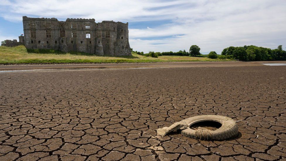 A castle overlooks extremely dry land caused by the UK heatwave